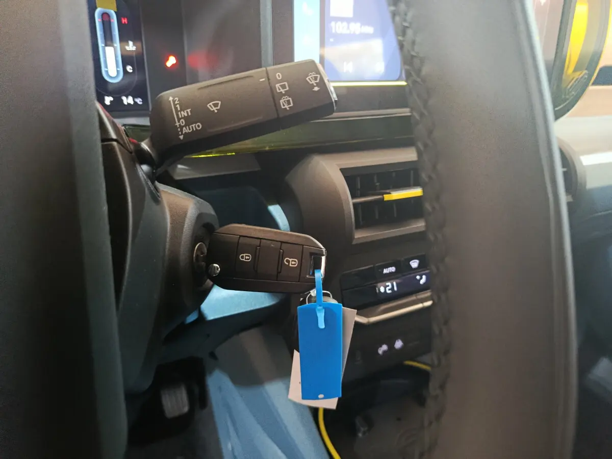 Gros plan intérieur sur le volant et la clé de la Fiat Grande Panda jaune, avec tableau de bord et commandes visibles.