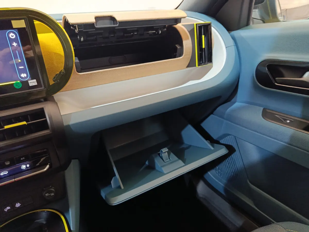 Intérieur FIAT Grande Panda 1.2 Hybrid 2025 côté passager, boîte à gants ouverte, tableau de bord bleu et beige.