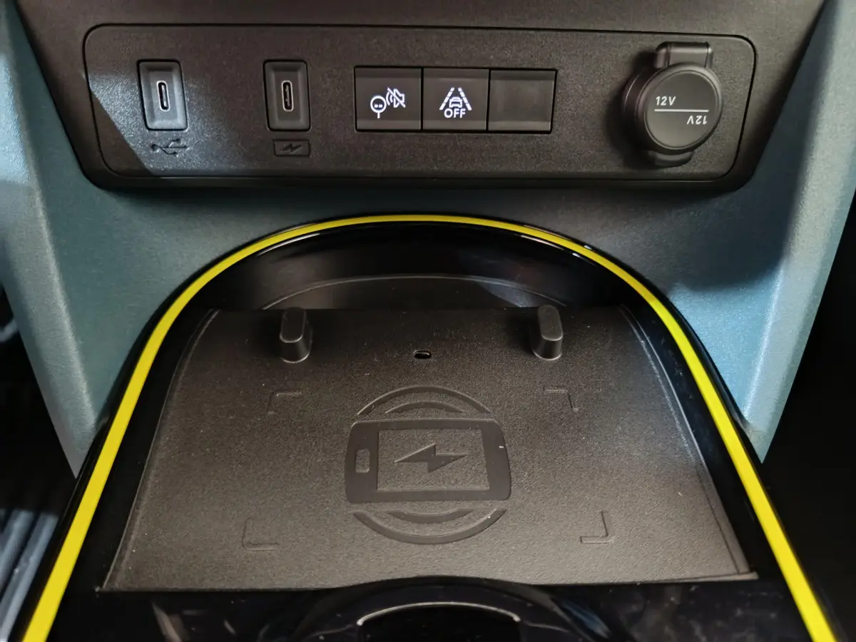Gros plan sur la zone de recharge sans fil entourée de jaune dans l’habitacle de la Fiat Grande Panda 1.2 Hybrid 2025.