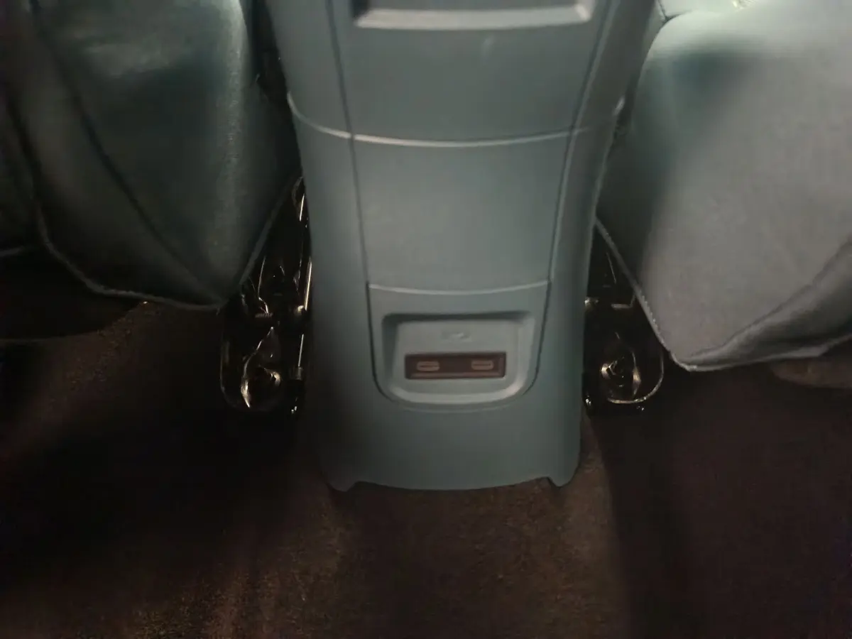 Vue rapprochée de la console centrale arrière grise avec ports USB dans l’habitacle de la Fiat Grande Panda jaune.