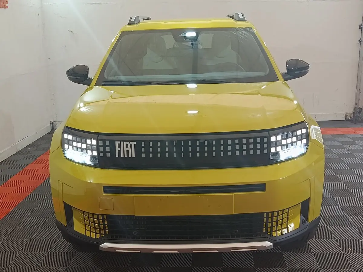 Vue avant d'une FIAT Grande Panda jaune 2025 avec phares LED et calandre pixelisée distinctive.
