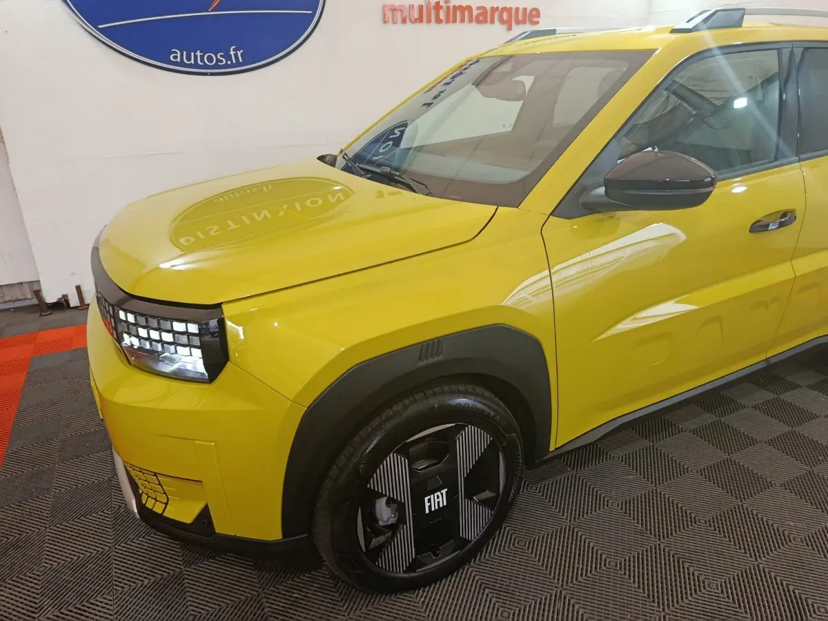 Vue 3/4 avant droit d'une FIAT Grande Panda jaune avec jantes noires et détails noirs contrastants.
