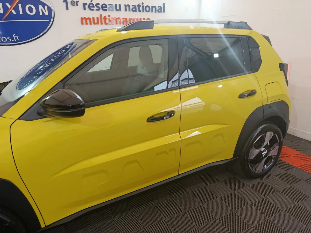 Vue de profil côté gauche d'une FIAT Grande Panda jaune avec détails de carrosserie et jantes noires.