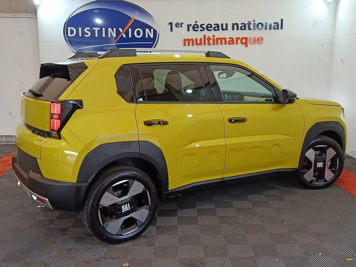 Vue côté droit arrière d'une FIAT Grande Panda 1.2 Hybrid jaune avec jantes noires au design graphique et toit noir.