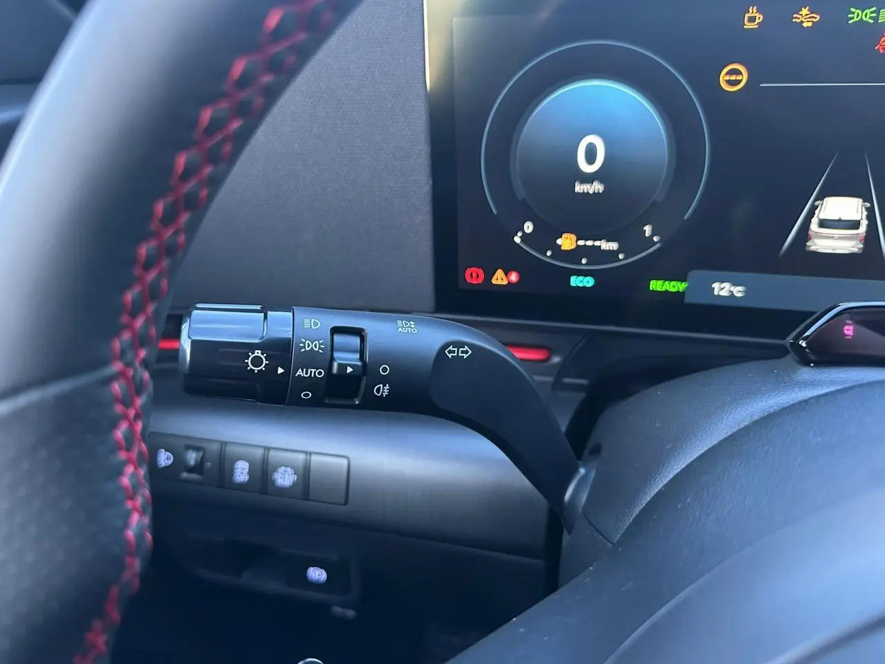 Vue rapprochée du combiné d'instruments et du commodo gauche du Hyundai KONA 2025 noir, affichage numérique et volant cuir.