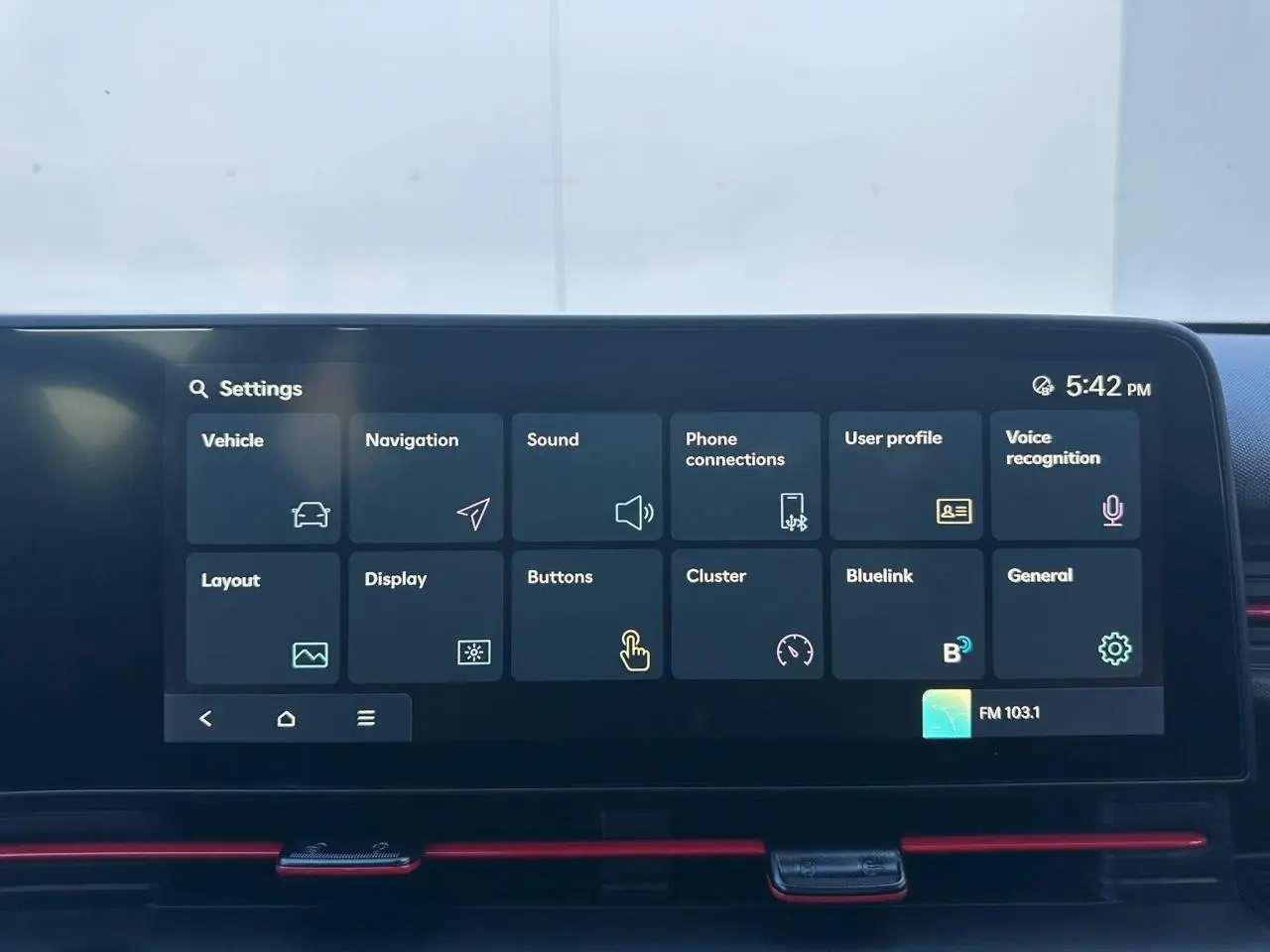 Écran tactile central du Hyundai Kona 2025 affichant le menu des réglages avec interface sombre et accents rouges.