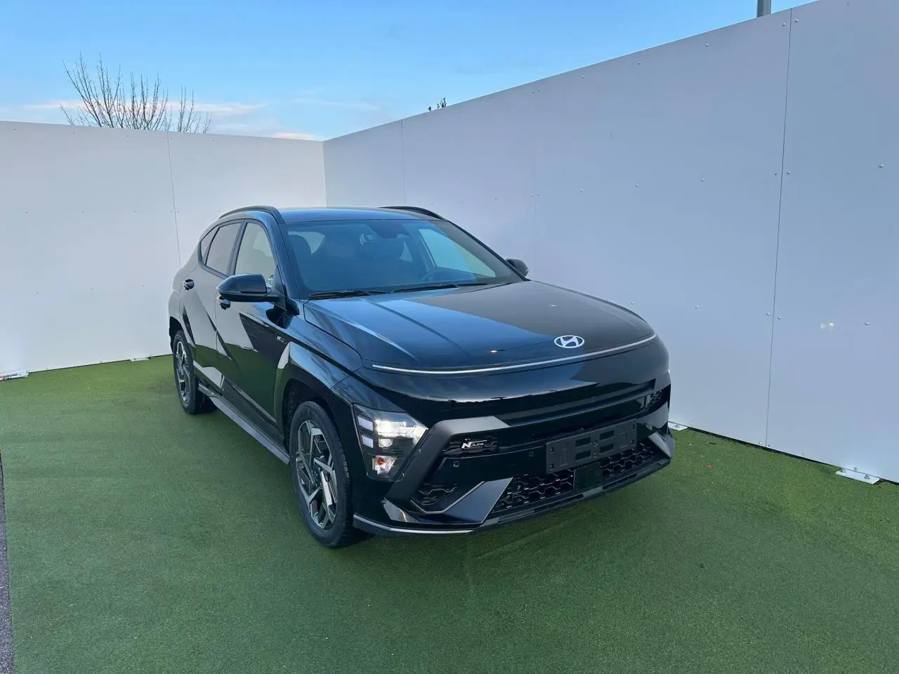 Hyundai Kona II 1.6 Hybrid N Line noir Abyss métal vu en 3/4 avant avec jantes alliage 18 pouces.