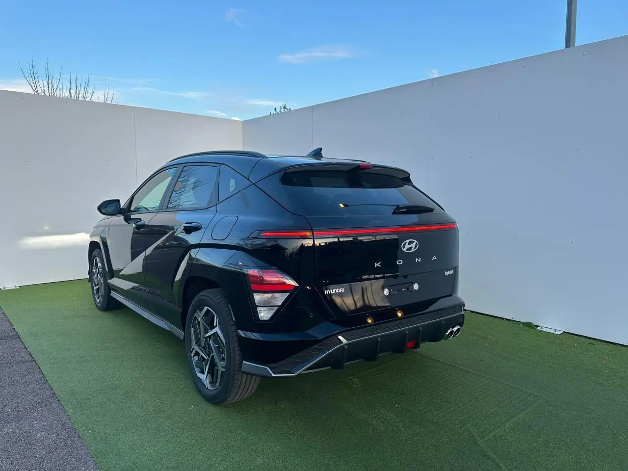 Vue 3/4 arrière droite du Hyundai KONA II noir Abyss Metal avec feux arrière LED et jantes alliage 18 pouces.