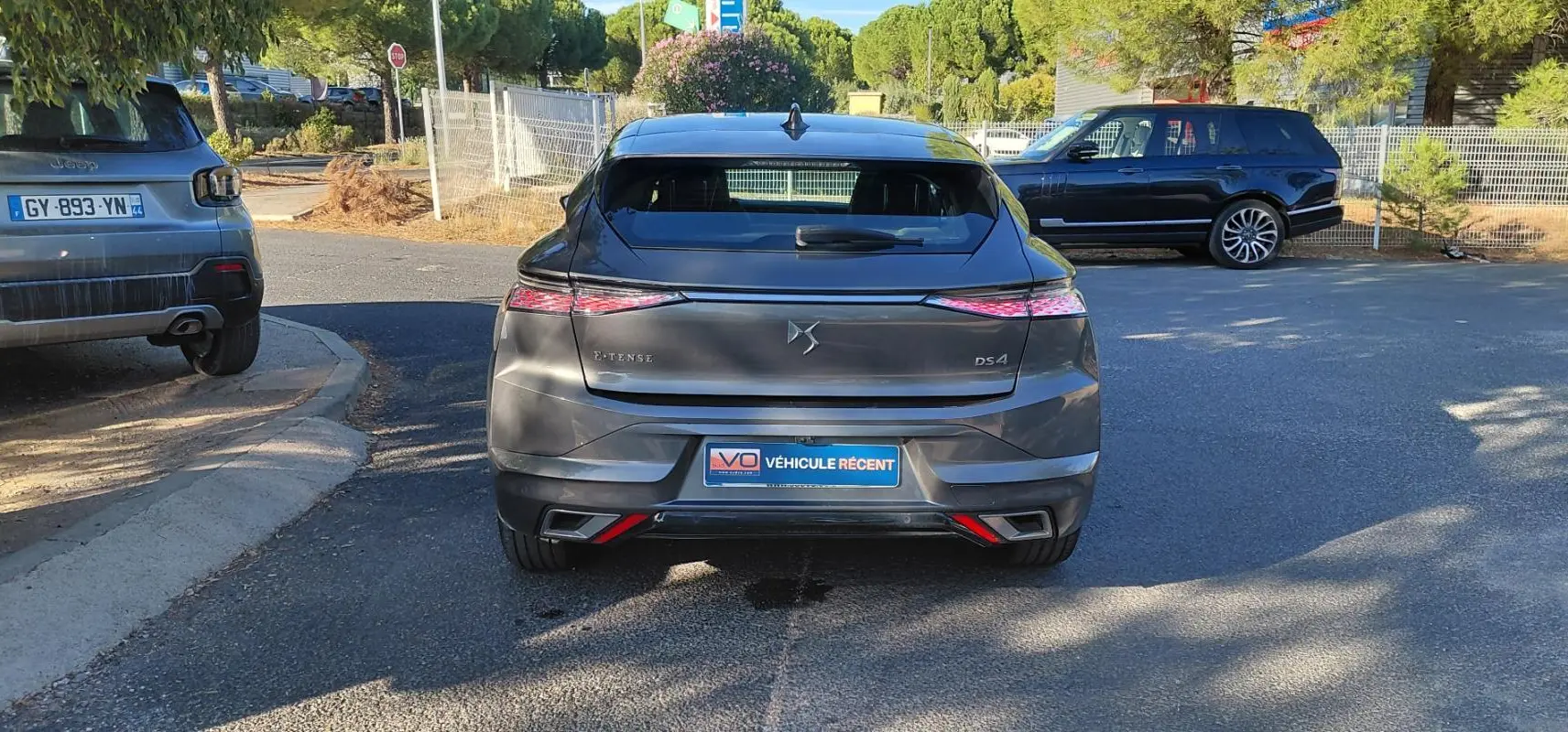 Vue arrière d'une DS4 Hybride E-Tense gris métallisé, avec feux LED effilés et double sortie d'échappement intégrée.