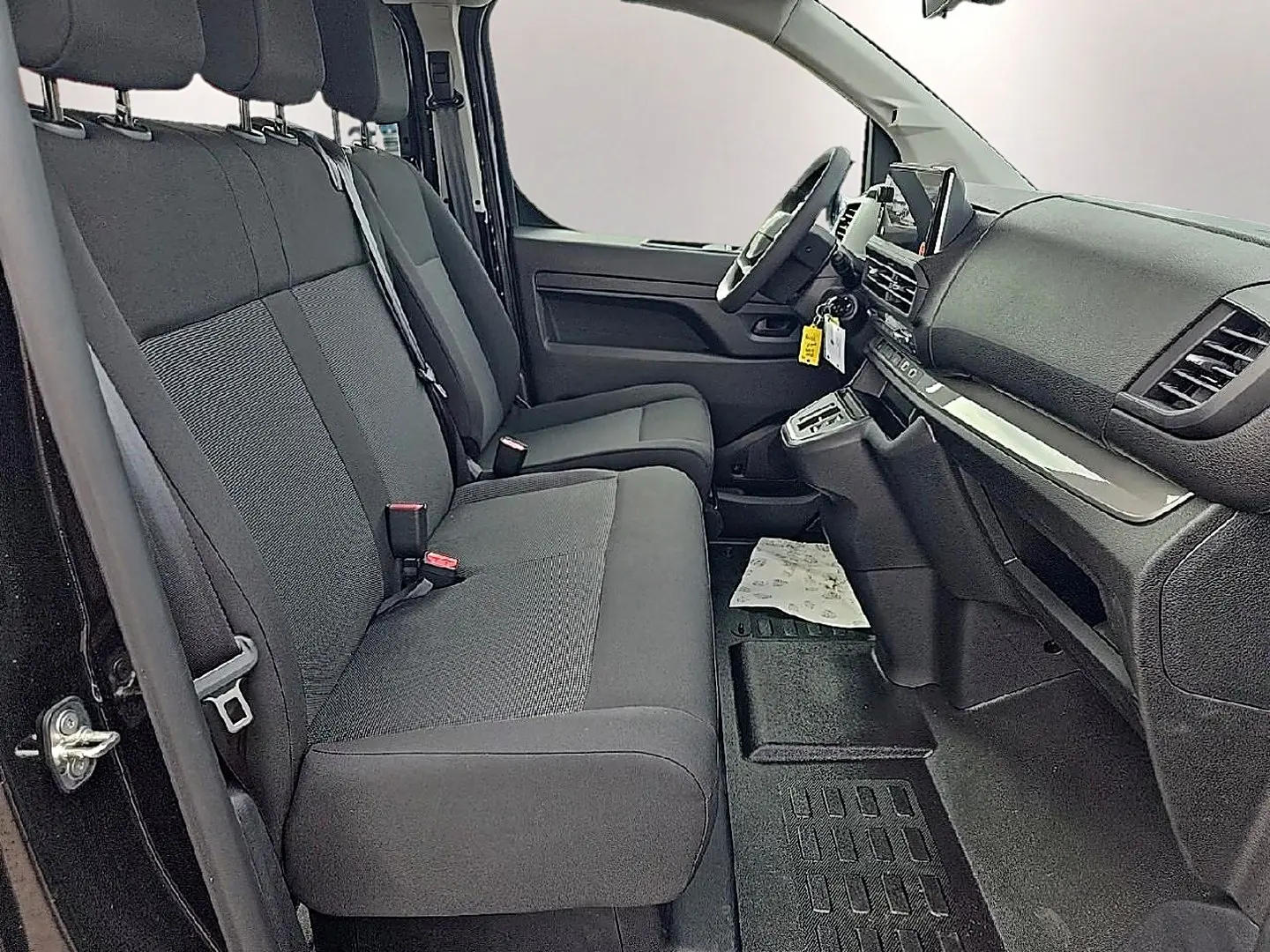 Vue intérieure côté conducteur du Fiat Scudo Combi 2026, sièges bi-ton gris et tableau de bord noir avec écran tactile.