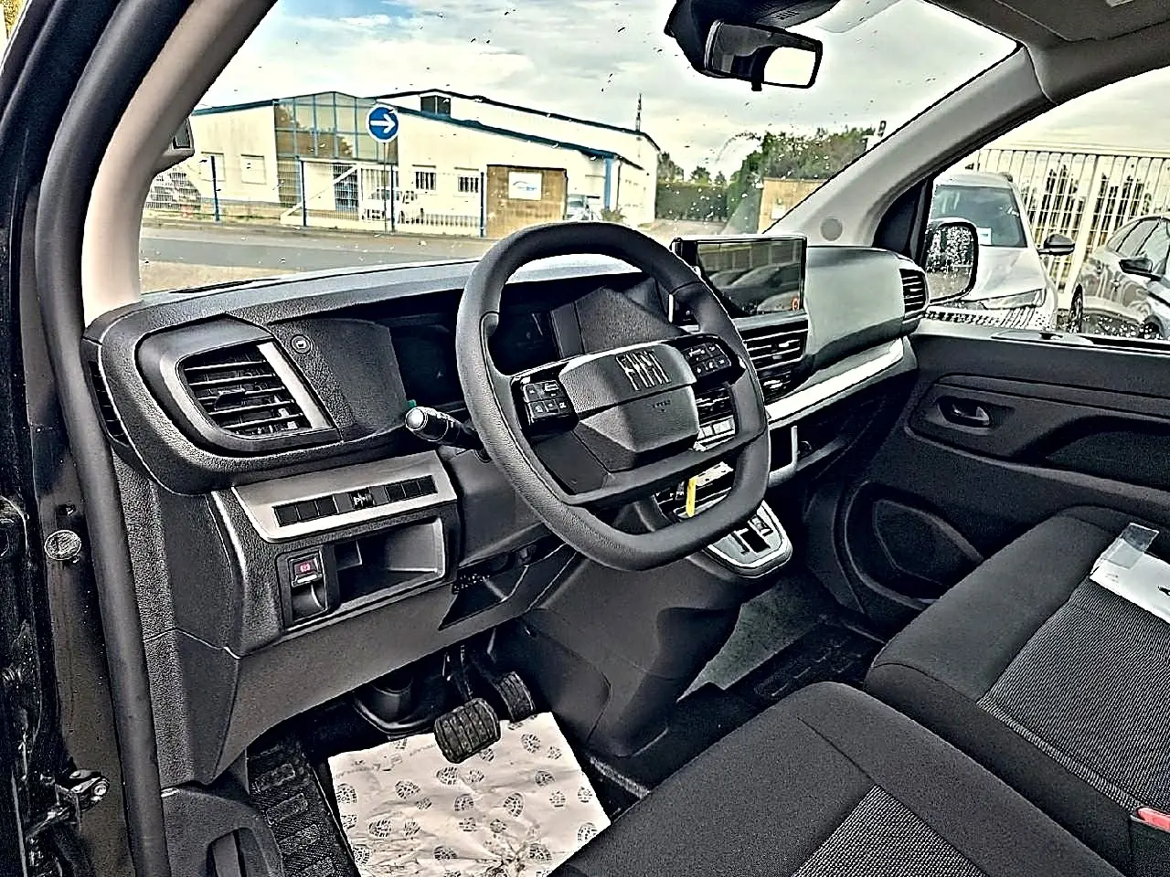 Vue intérieure côté conducteur du Fiat Scudo Combi noir 2026 avec tableau de bord moderne et volant multifonctions.