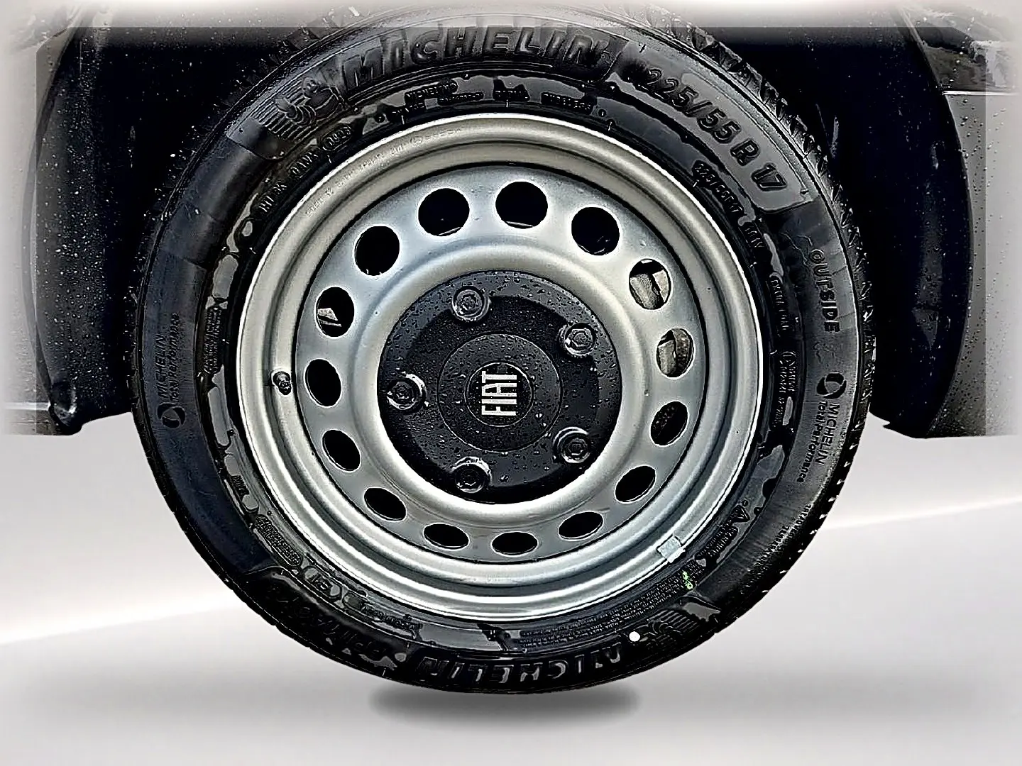 Gros plan sur la roue avant droite noire du Fiat Scudo Combi avec jante acier grise et logo central Fiat.