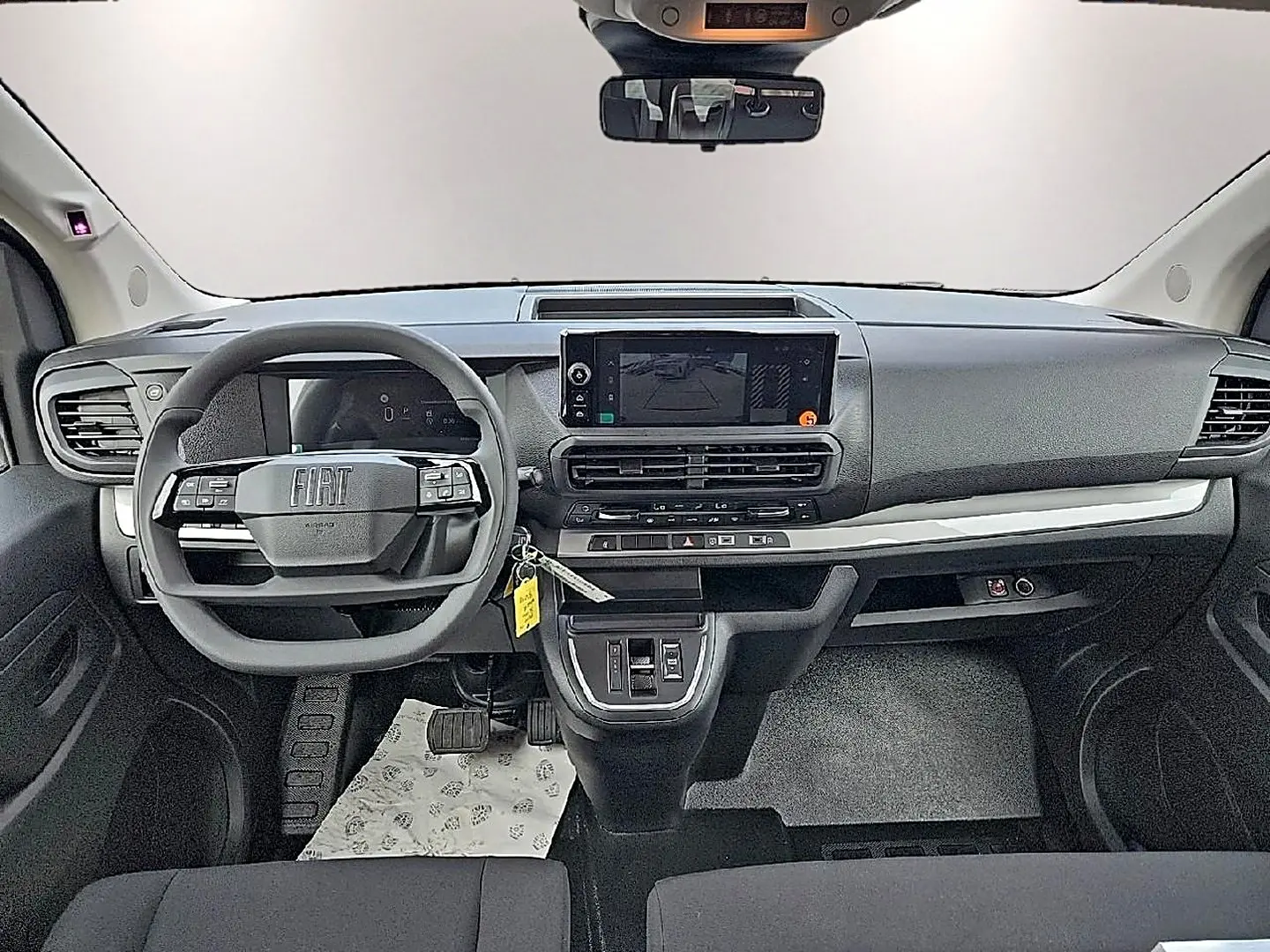Tableau de bord noir du Fiat Scudo Combi 2026 vu de face, avec volant multifonction et écran tactile central.