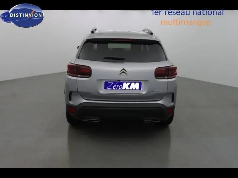Vue arrière d'un Citroën C5 Aircross gris acier avec feux arrière LED et barres de toit visibles.
