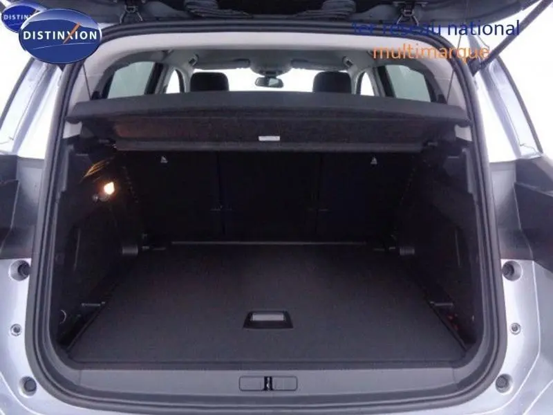 Coffre ouvert vu de l'arrière d'un Citroën C5 Aircross gris acier, montrant l'espace de chargement et les sièges arrière.