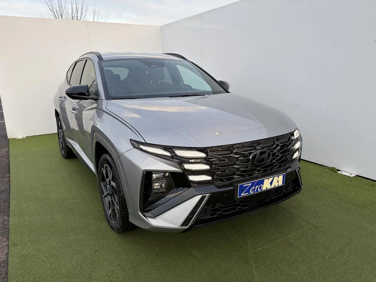 Hyundai Tucson 2025 hybride N Line en Shimmering Silver, vue 3/4 avant avec calandre noire distinctive.