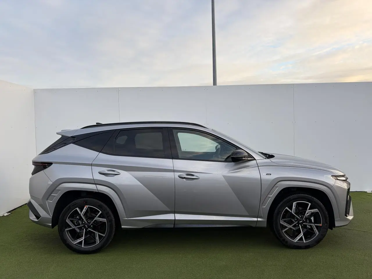 Hyundai Tucson 2025 hybride en Shimmering Silver Metal, vue profil côté gauche avec jantes alliage 19'' N Line.