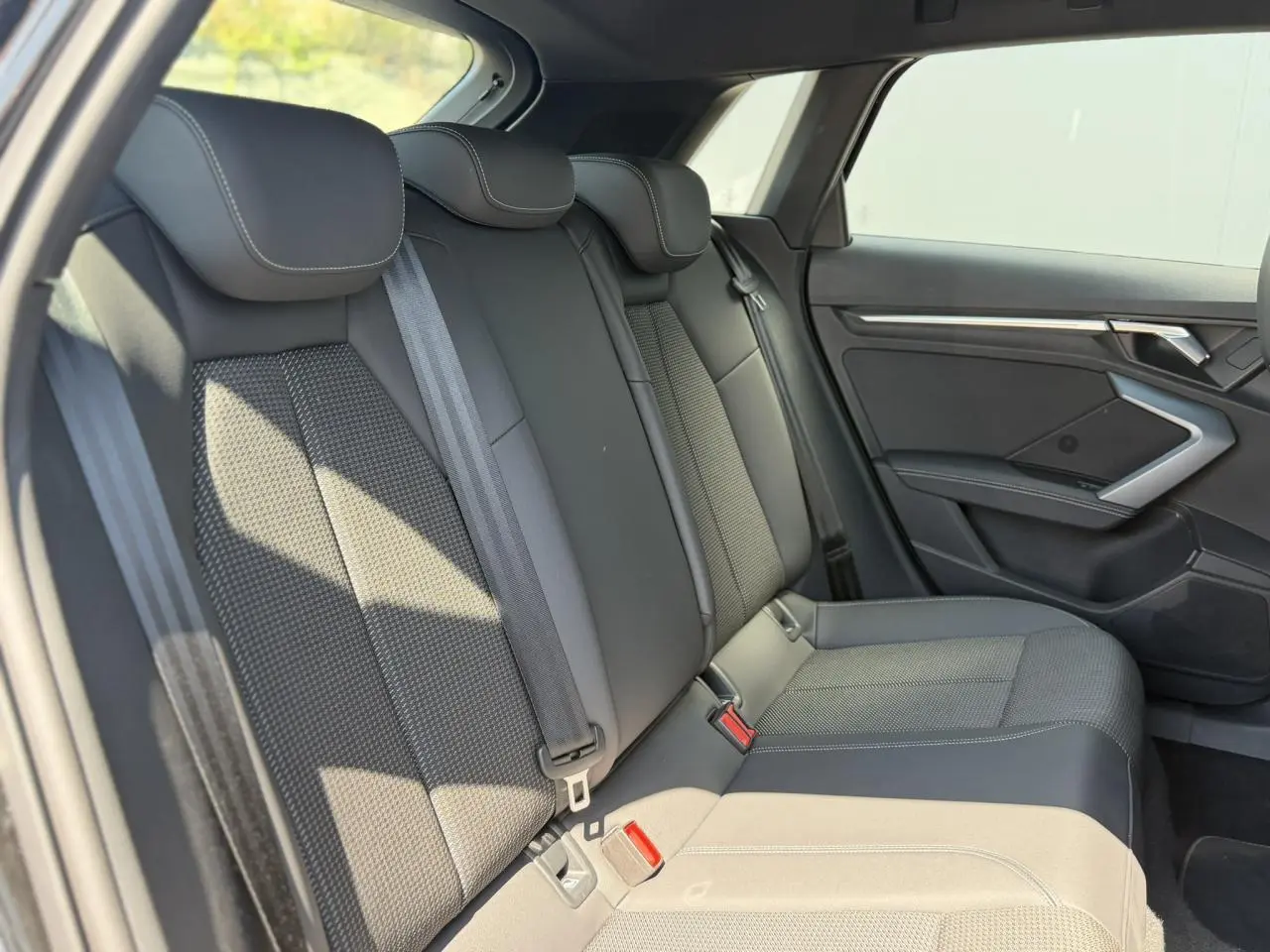 Vue latérale droite de la banquette arrière en tissu noir avec ceintures de sécurité sur Audi A3 Sportback 2025.