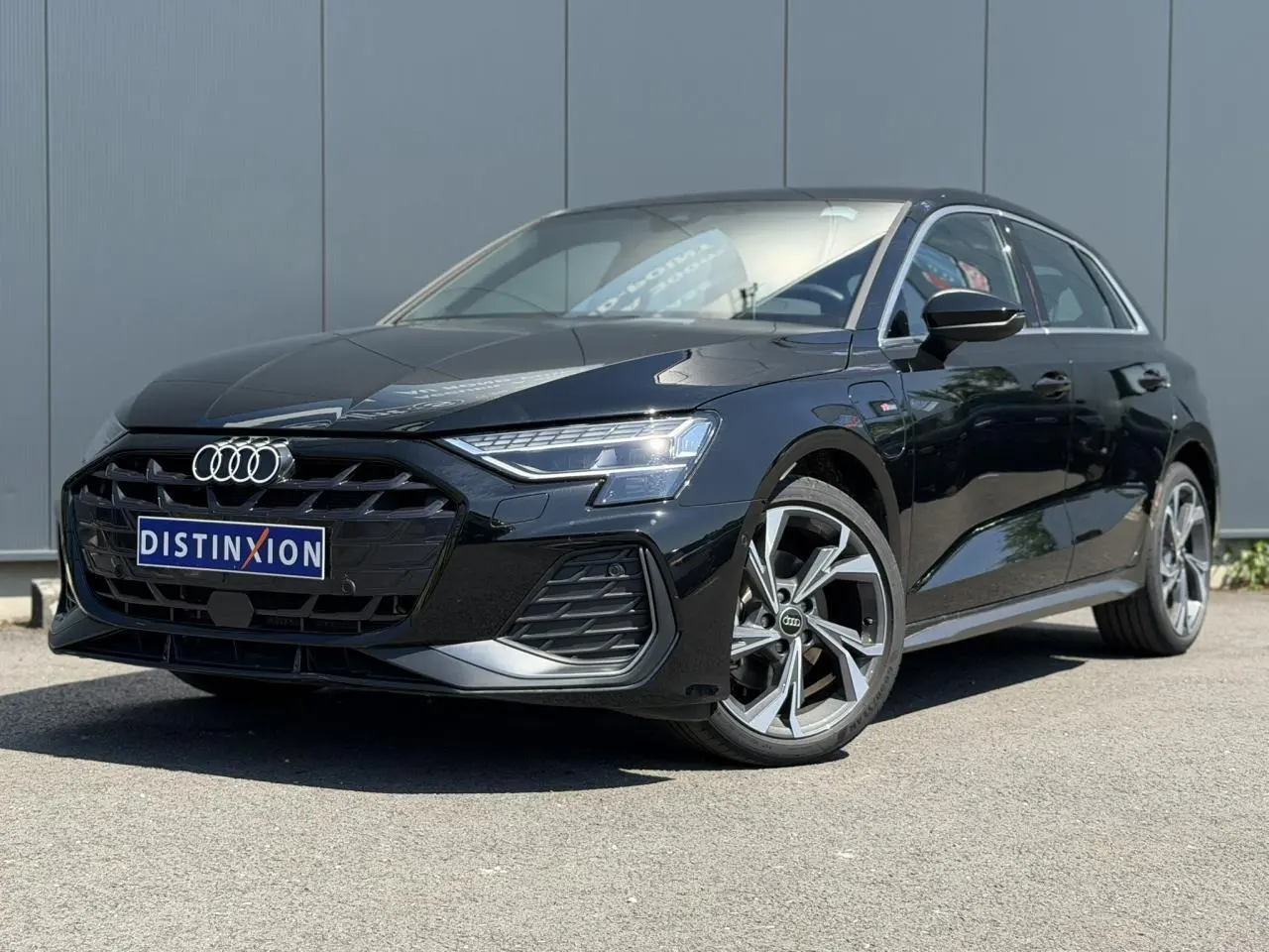Audi A3 Sportback noir Mythe en 3/4 avant droit, avec calandre S-Line et jantes alliage 5 branches en Y.