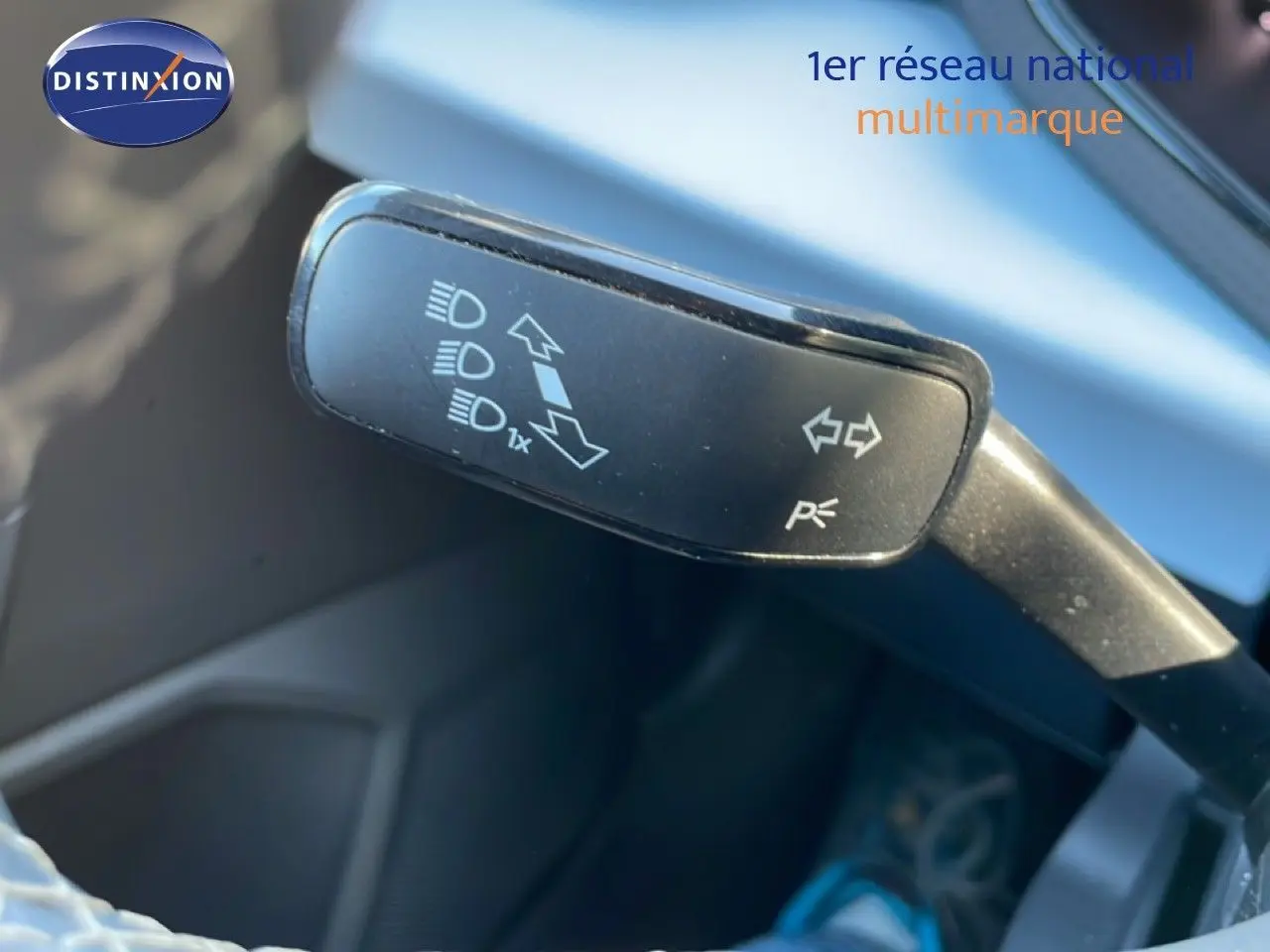 Gros plan sur la manette de clignotant du SEAT Arona 2025, intérieur gris noir avec détails de commandes lumineuses.