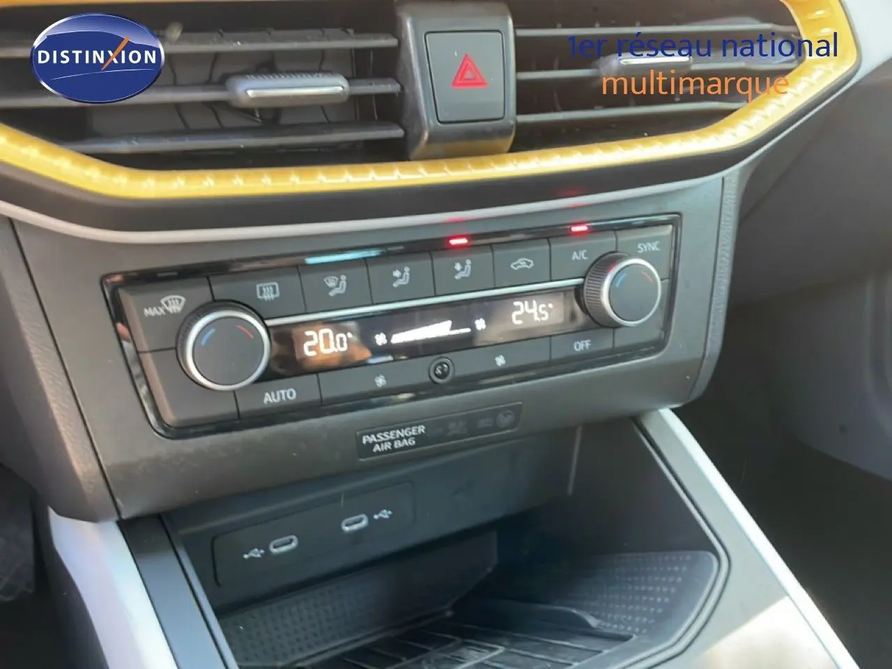 Vue rapprochée de la console centrale du SEAT Arona 2025, avec commandes de climatisation et ports USB visibles.