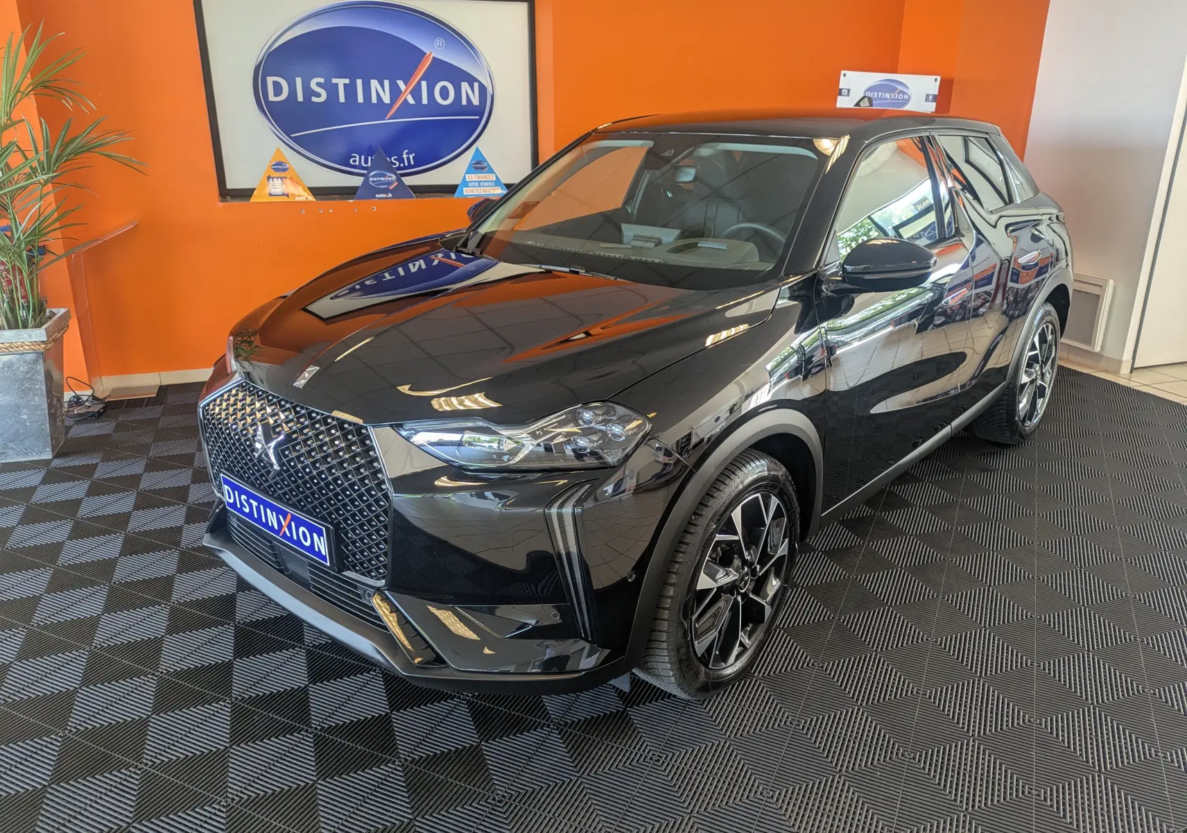 DS3 2024 noir en 3/4 avant droit, avec calandre distinctive et jantes alliage bicolores 18 pouces.