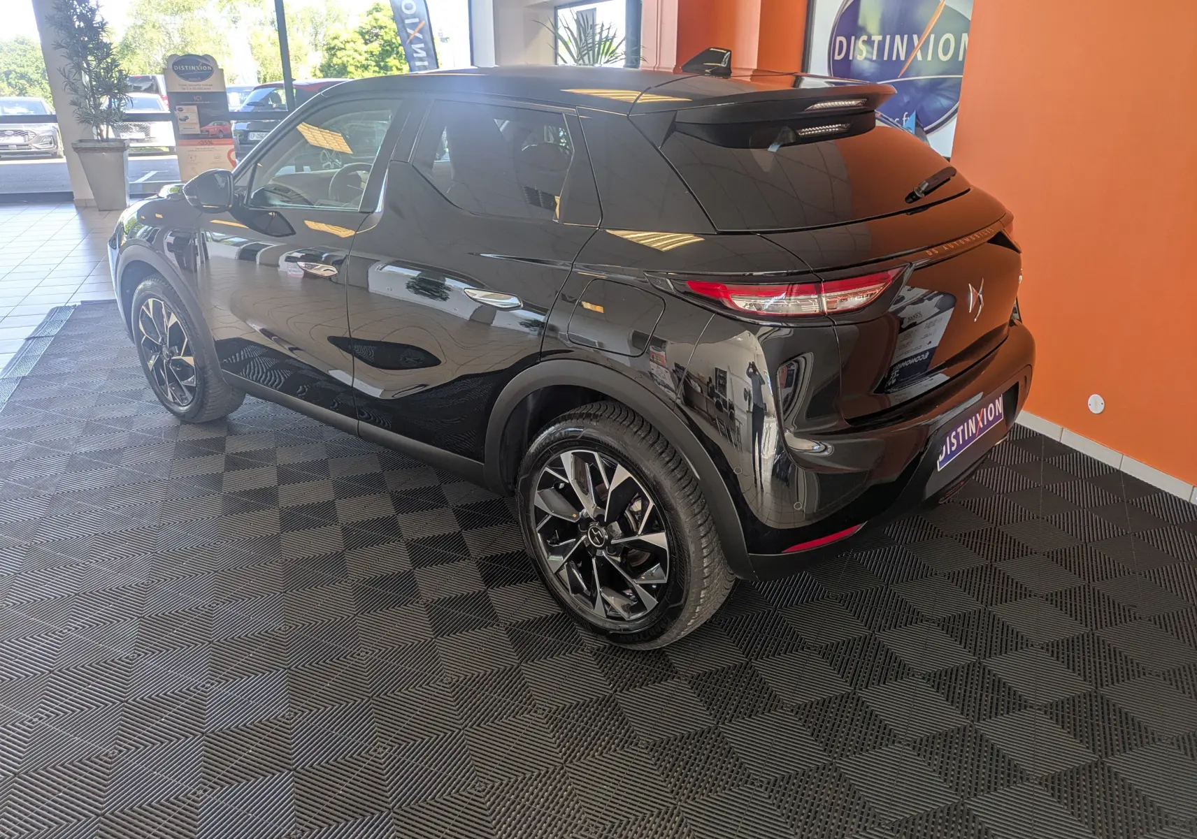 DS3 noir vue 3/4 arrière droit en intérieur, avec jantes alliage noires et toit noir brillant