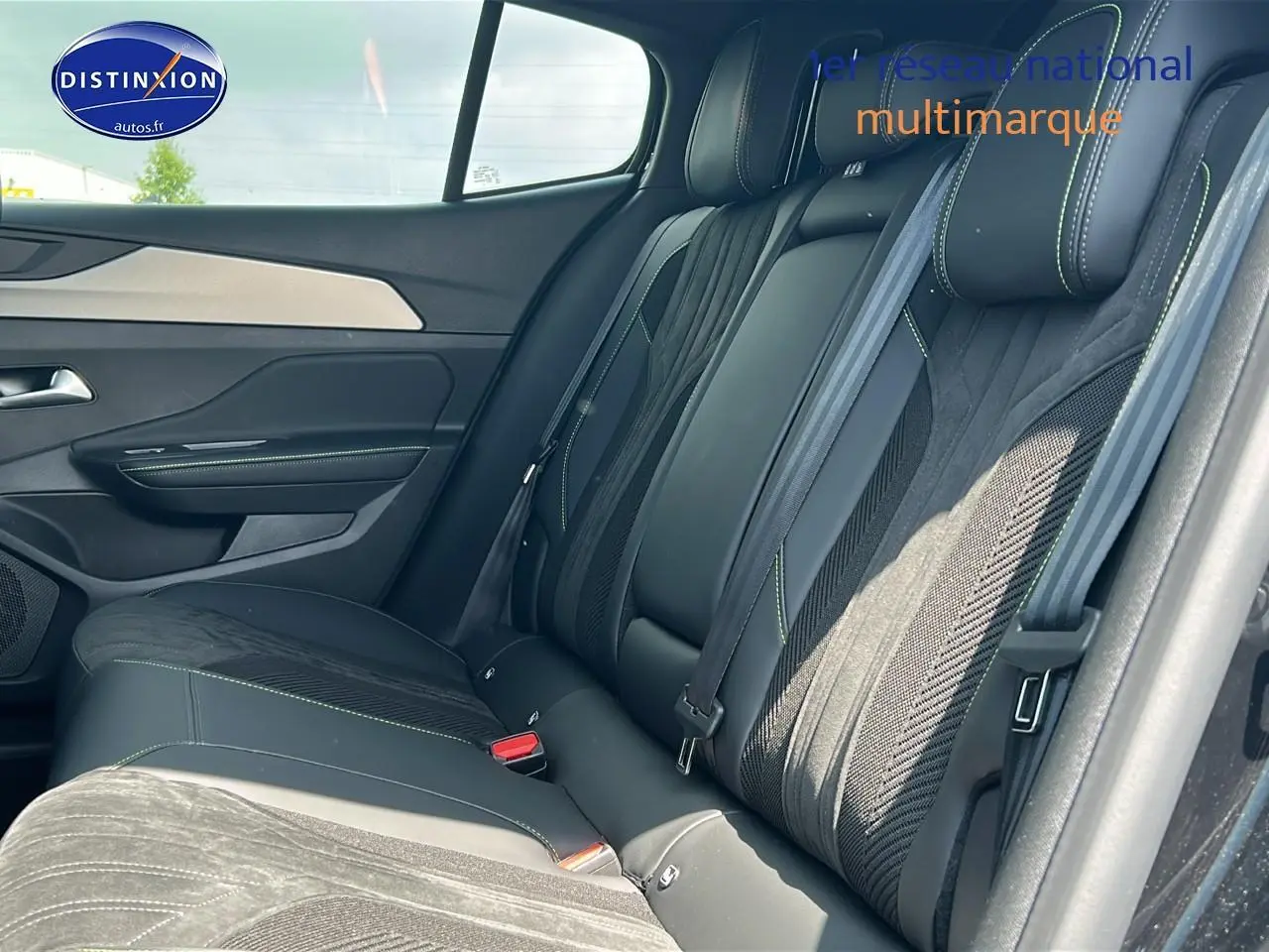 Vue intérieure côté droit sur la banquette arrière noire avec surpiqûres vertes du Peugeot 408 Hybrid 145 GT 2024.