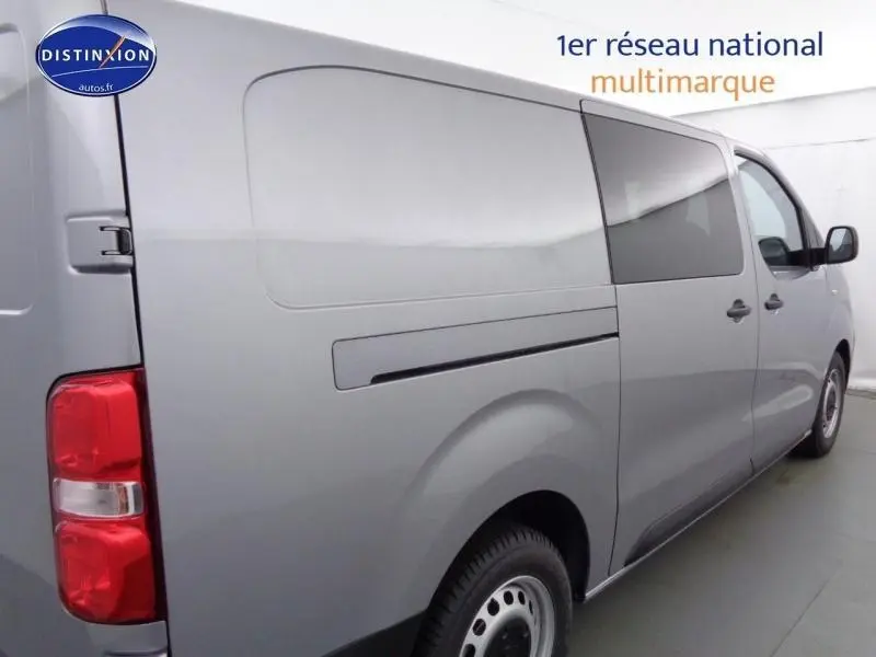 Vue latérale droite du Peugeot Expert Fourgon XL gris acier métal 2023 avec porte latérale arrière et vitres surteintées.