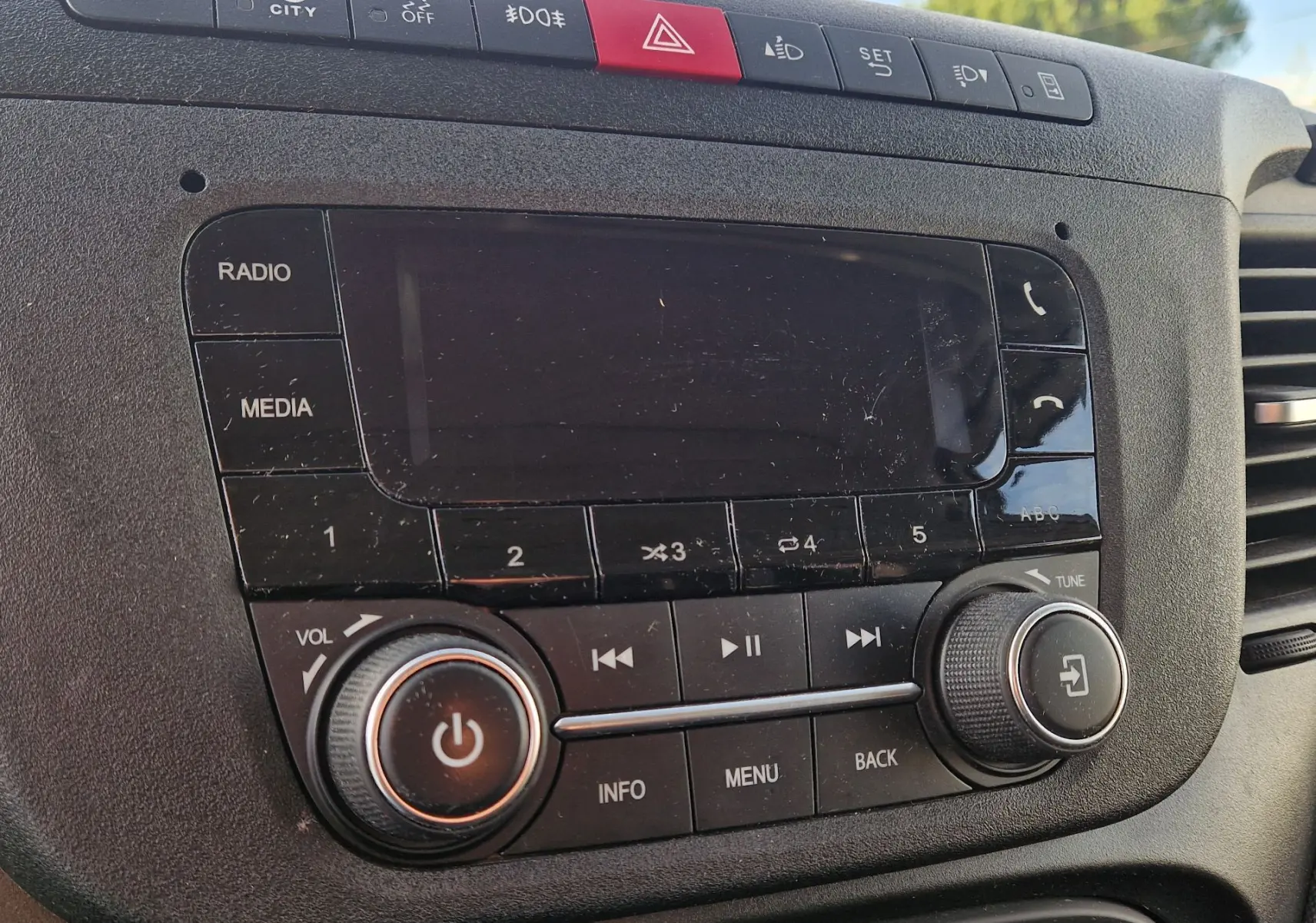 Gros plan sur la console centrale noire de l'IVECO Daily Fourgon 2023, montrant l'autoradio et les commandes multimédias.