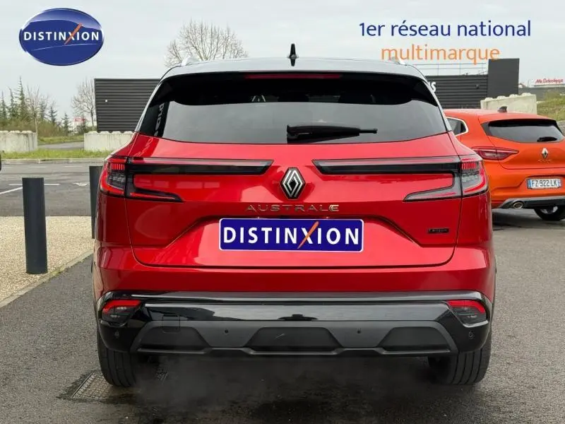 Vue arrière d'un Renault Austral 2025 rouge flamme, mettant en valeur ses feux LED étirés et son logo central chromé.