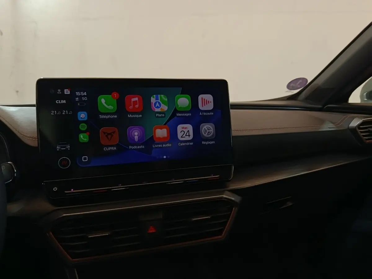 Vue intérieure du tableau de bord du CUPRA Formentor 1.4 e-HYBRID 2024 avec écran tactile central affichant Apple CarPlay.