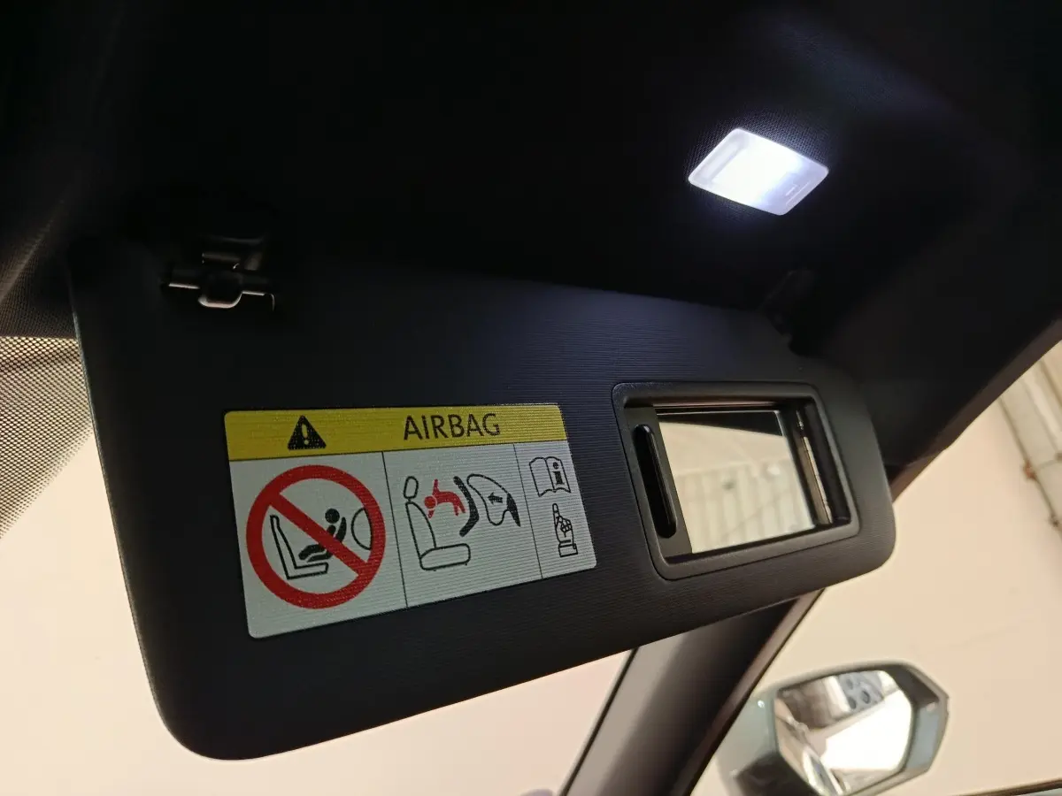 Détail du pare-soleil côté conducteur avec miroir intégré et étiquette airbag dans un CUPRA Formentor noir.