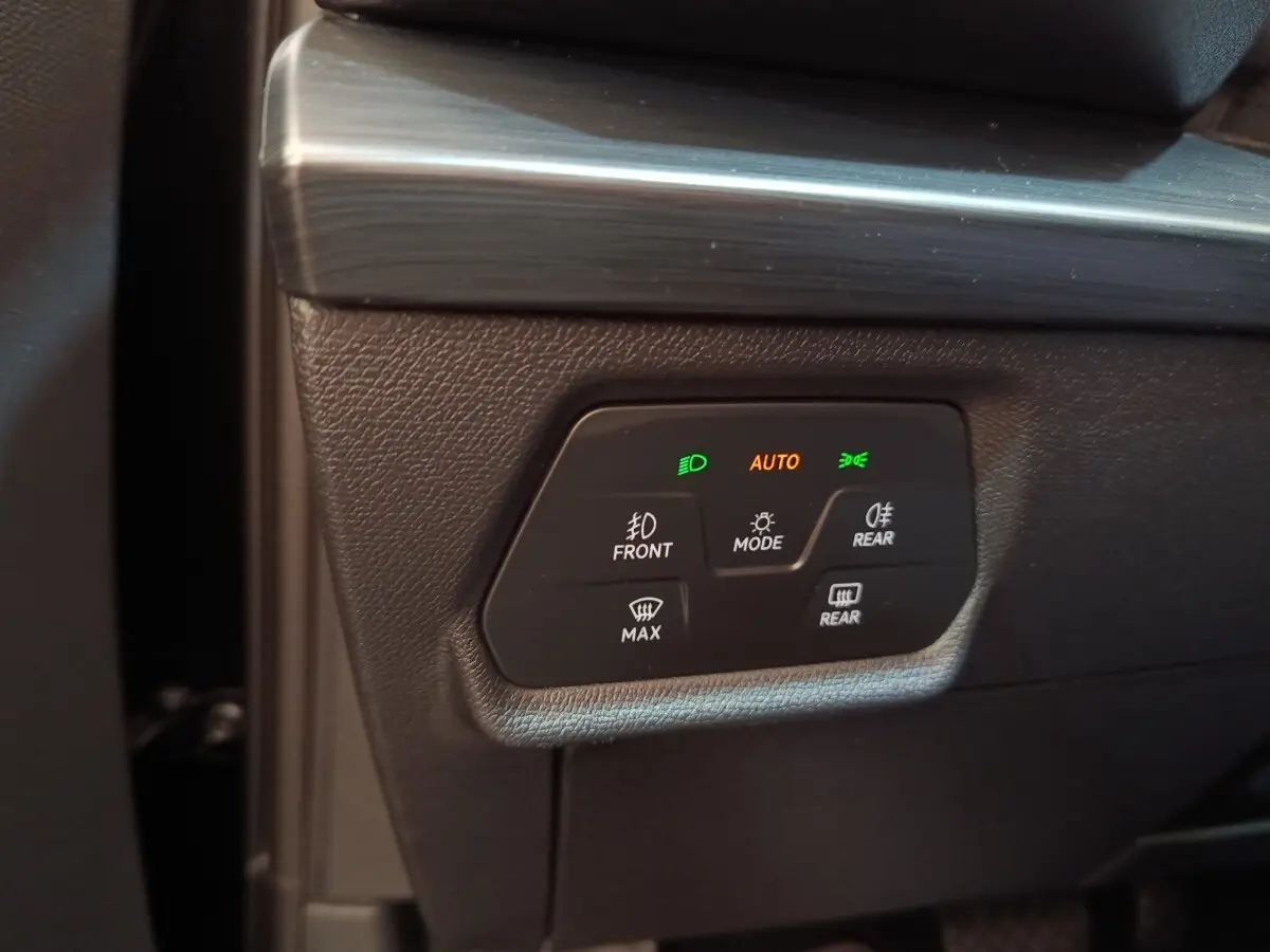 Gros plan sur les commandes d’éclairage et désembuage du tableau de bord noir du CUPRA Formentor 2024.