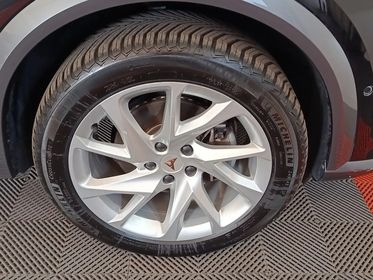 Gros plan sur la roue avant droite d'une CUPRA Formentor noire avec jante argentée et logo CUPRA central.