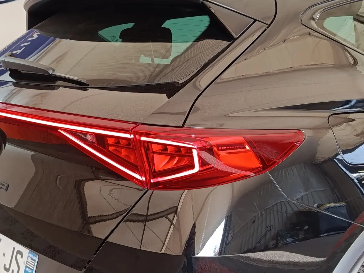 Gros plan sur le feu arrière droit rouge du CUPRA Formentor noir 2024 avec rails de toit assortis visibles.