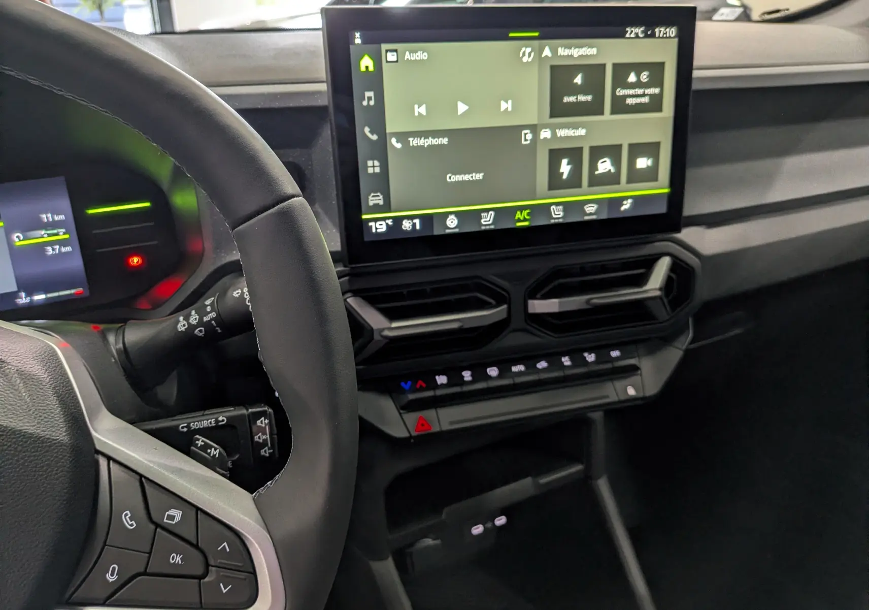 Vue intérieure du tableau de bord du Dacia Duster Hybrid-G 150 CH avec écran tactile et commandes au volant.