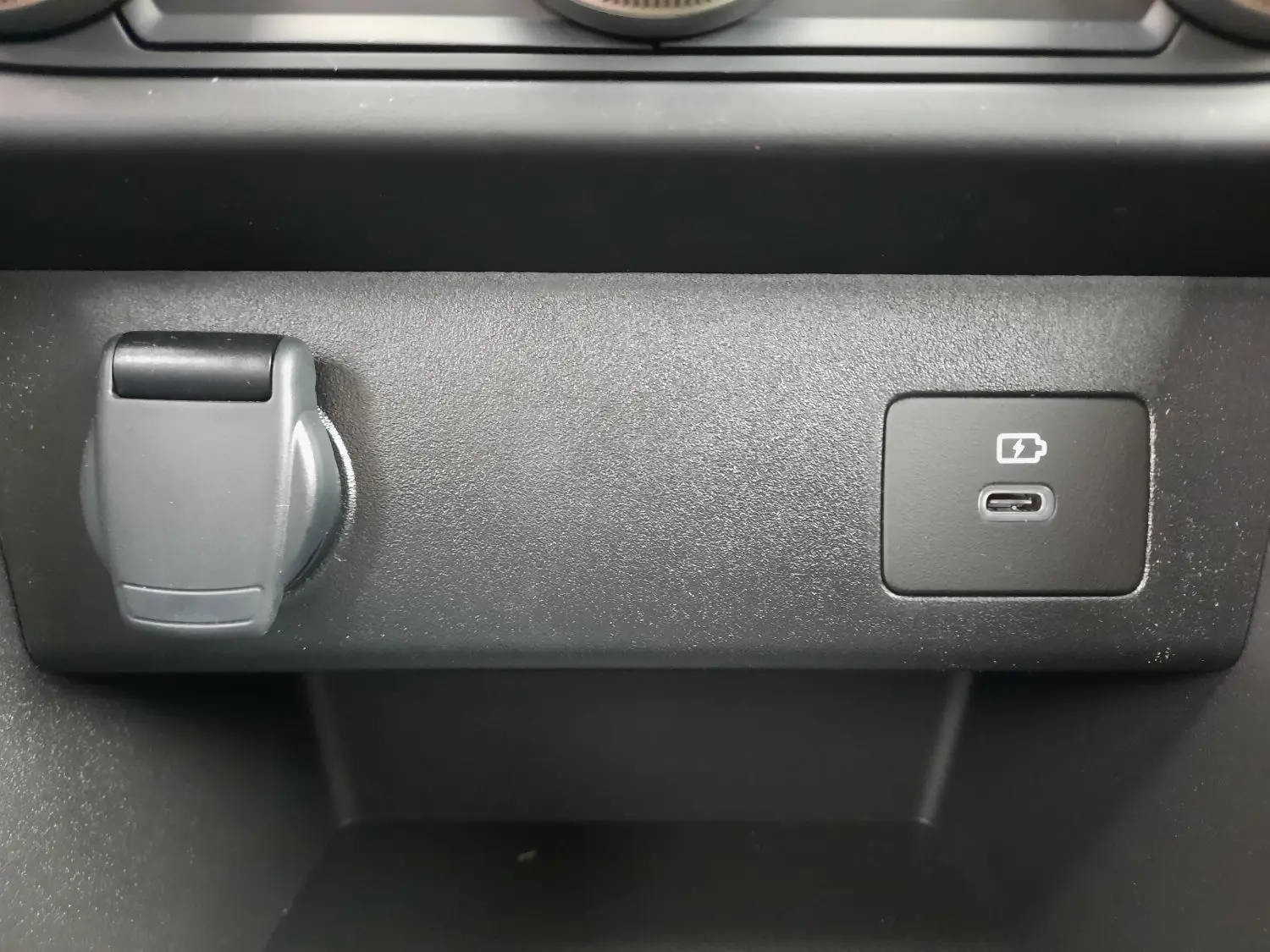 Gros plan sur la prise USB-C et l’allume-cigare dans l’habitacle noir du Dacia Sandero Stepway 2025