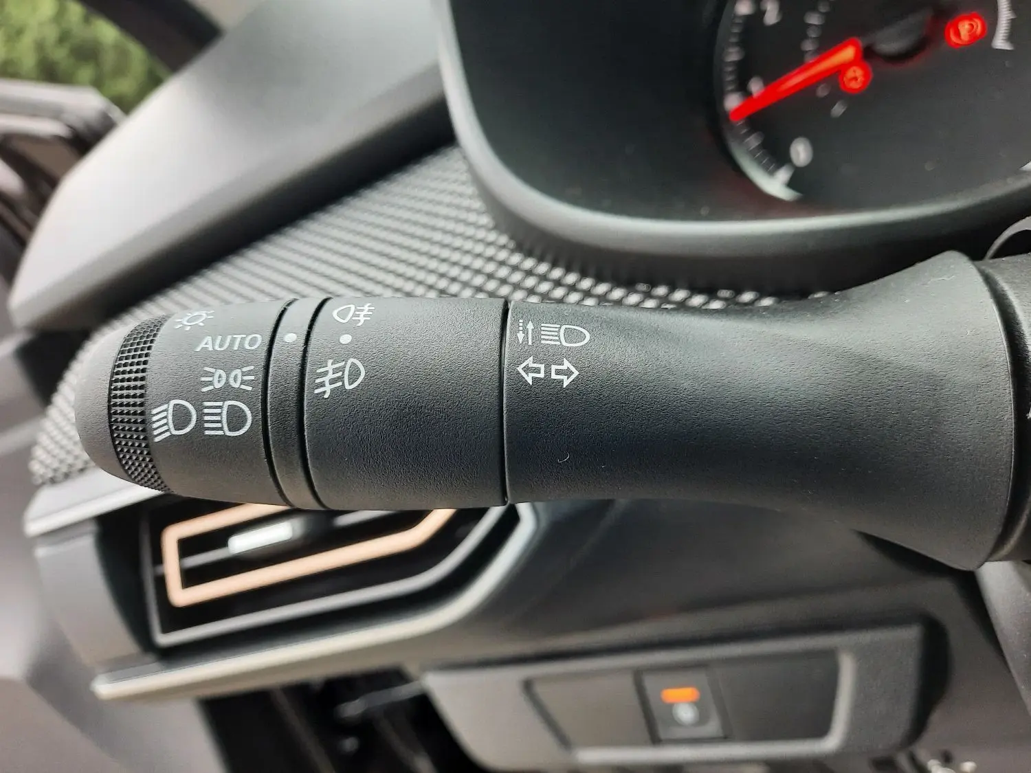 Gros plan sur la commande des phares et clignotants dans l'habitacle d'une Dacia Sandero Stepway noir nacré 2025.