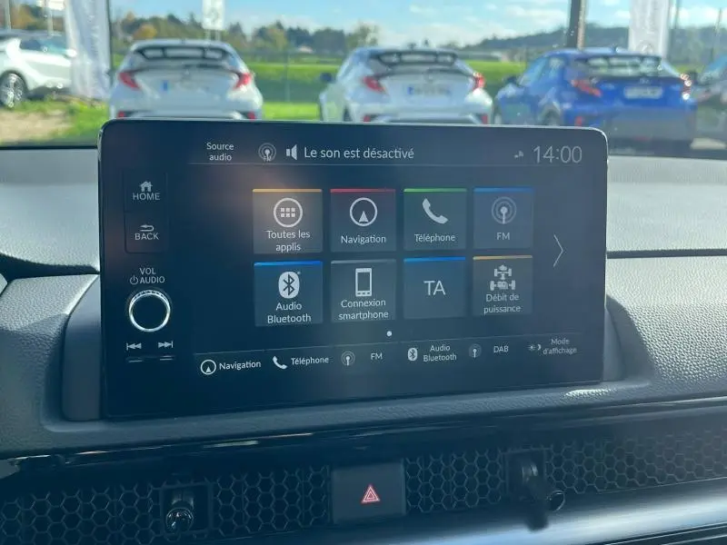 Vue intérieure centrée sur l'écran tactile multimédia du Honda CR-V 2024 avec tableau de bord noir et vue arrière floue.
