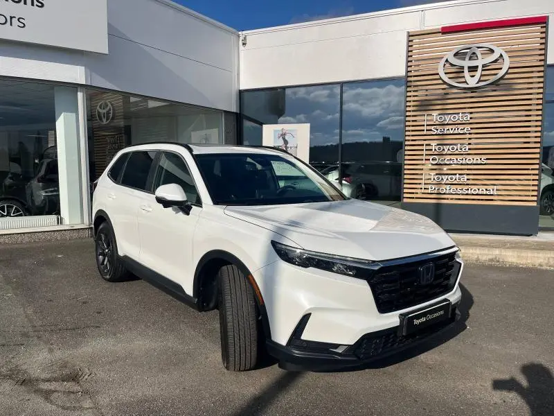 Vue 3/4 avant droite du Honda CR-V 2024 blanc Diamant Brillant Premium métallisé, avec calandre noire et jantes foncées.