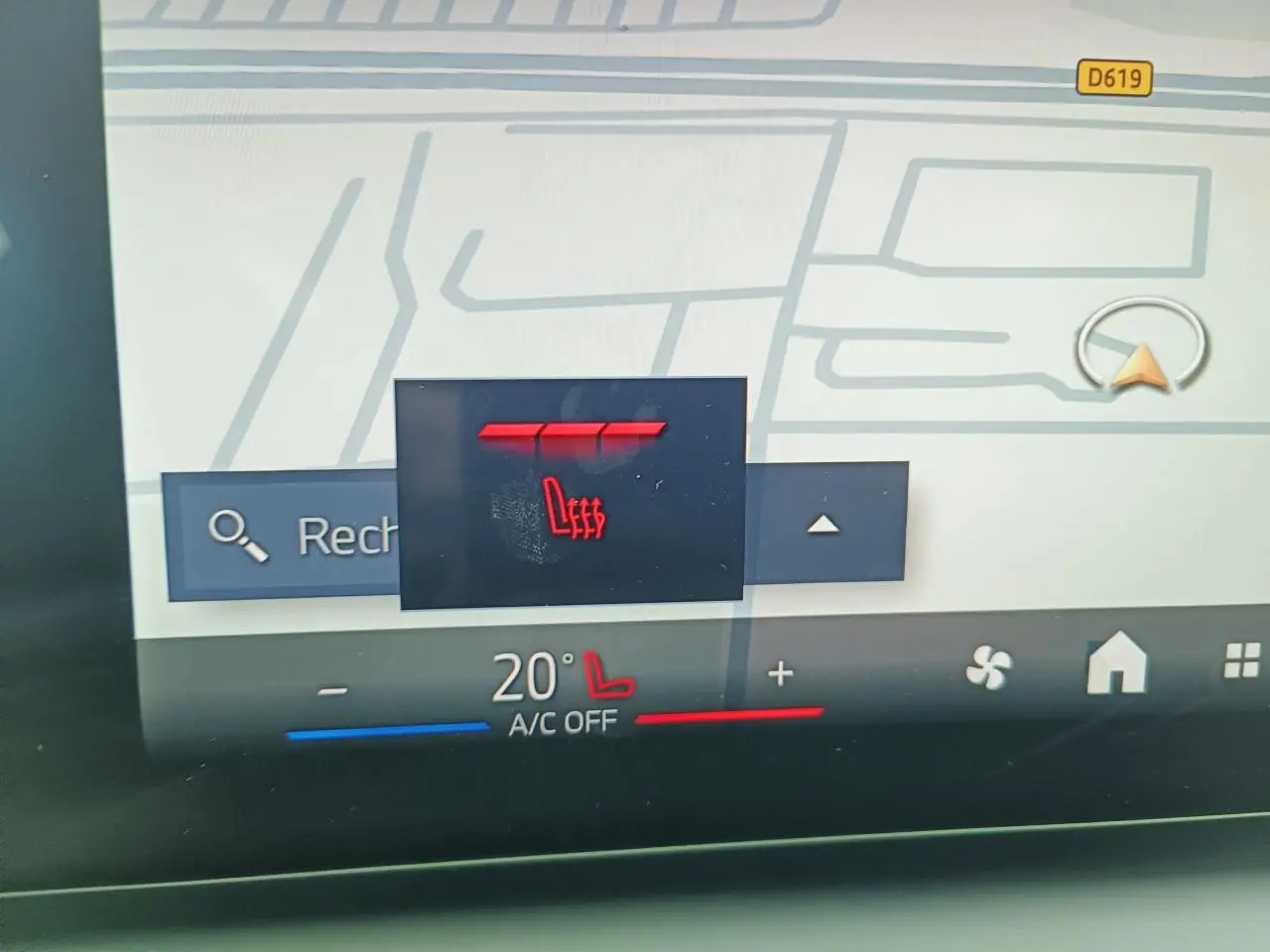 Gros plan sur l'écran tactile intérieur de la BMW Série 1 2025, affichant la commande de siège chauffant rouge.