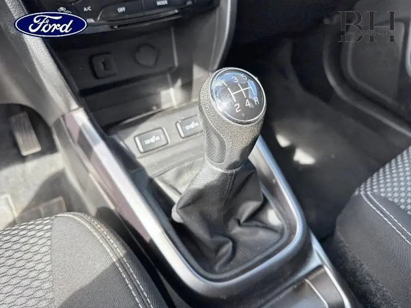 Levier de vitesses manuel en gros plan dans l'habitacle noir d'un Suzuki Vitara 2019, avec coutures visibles sur les sièges.