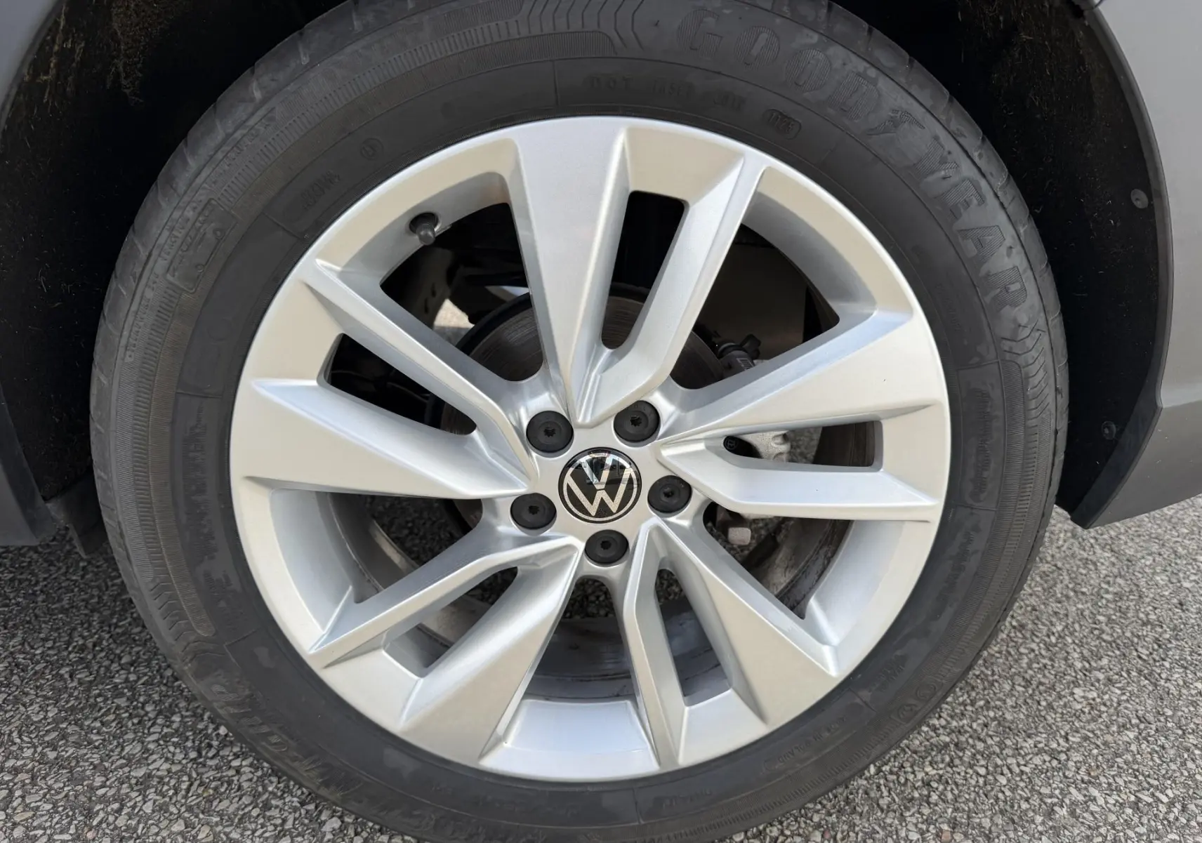 Gros plan sur la jante alliage 17 pouces Bangalore argentée du Volkswagen Taigo bleu, avec logo VW au centre.