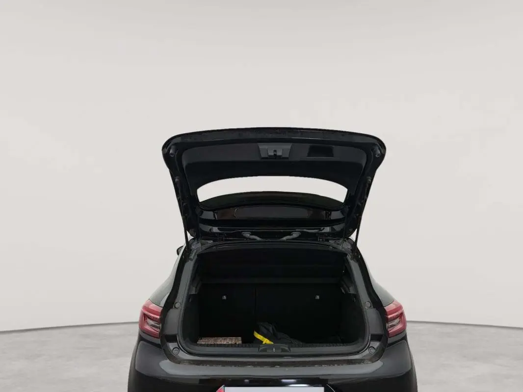 Vue arrière d’une Renault Clio V TCe 100 GPL Evolution noire de 2023 avec coffre ouvert montrant l’espace de chargement.