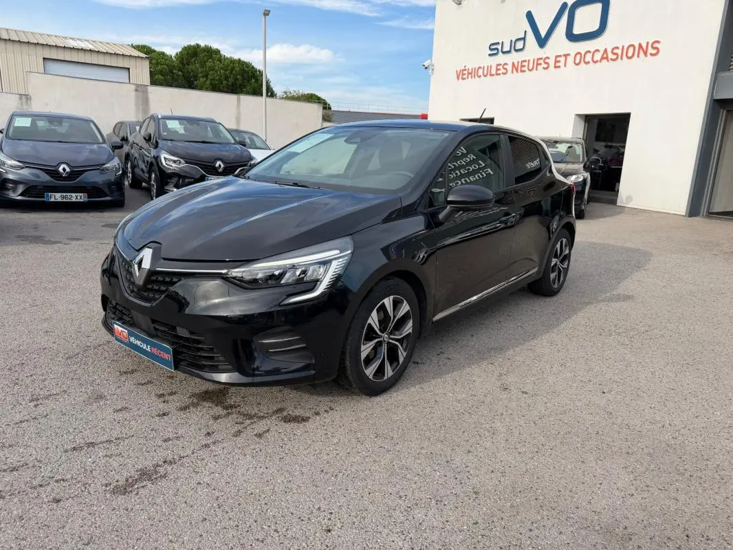 Renault Clio V TCe 100 GPL noir vue 3/4 avant droit, garée devant un concessionnaire Sud VO.