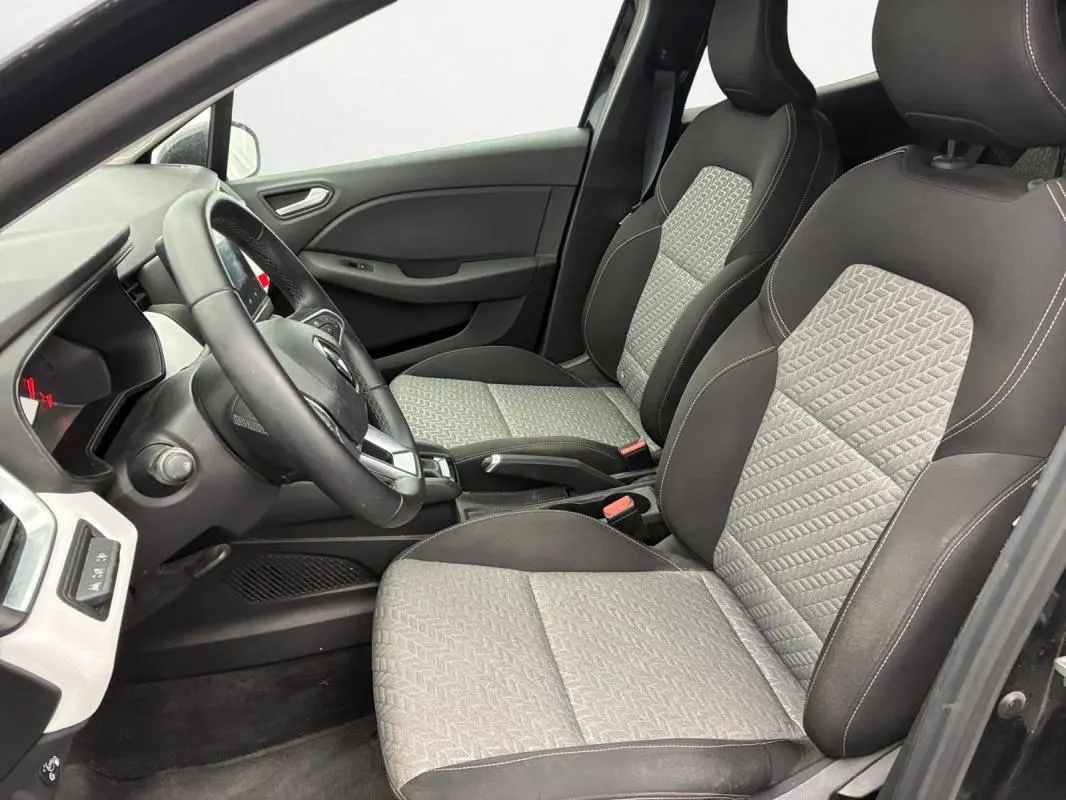 Vue intérieure côté conducteur de la Renault Clio 2023 noir, sièges bi-matière gris et noir avec volant multifonction.