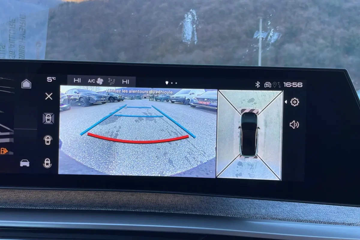 Vue écran caméra de recul et vue aérienne du Peugeot 5008 gris titane hybride 2025 en stationnement.