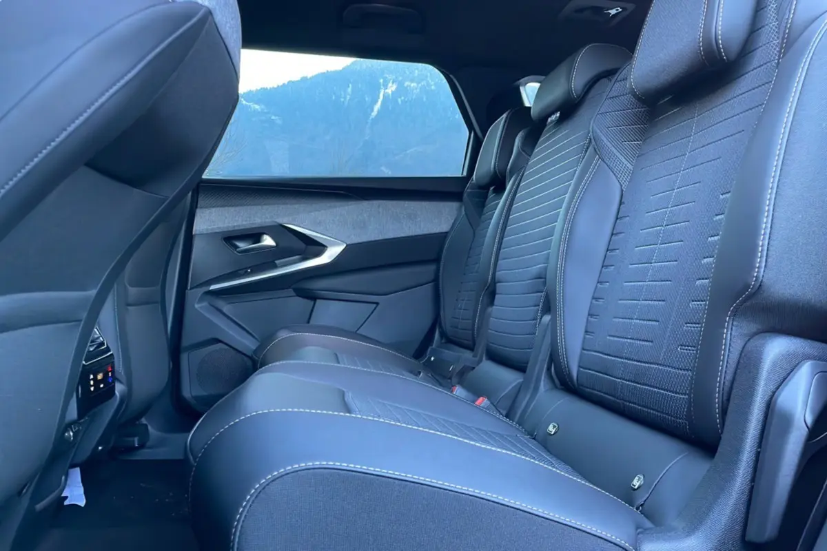 Vue latérale intérieure des sièges arrière en cuir noir avec surpiqûres blanches du Peugeot 5008 Hybrid 145 Allure Plus 2025.