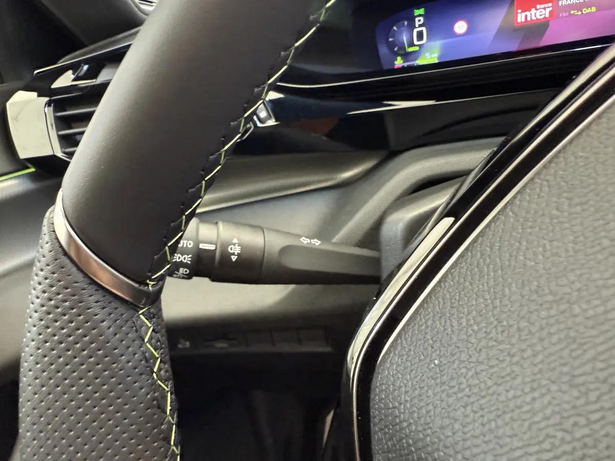Gros plan sur le volant cuir et le combiné numérique 10 pouces de la Peugeot 308 Hybrid 136 e-DCS6 GT 2024.